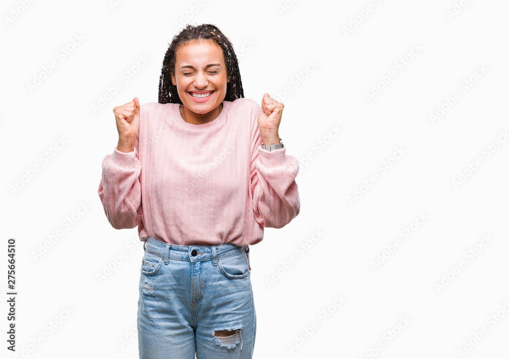 Young braided hair african american girl wearing sweater over isolated background excited for success with arms raised celebrating victory smiling. Winner concept. Young braided hair african american girl wearing sweater over isolated background excited for success with arms raised celebrating victory smiling. Winner concept.