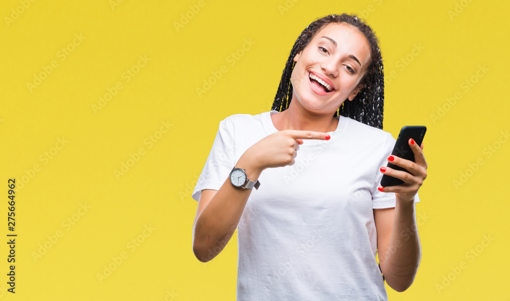 Naklejka premium Young braided hair african american girl showing using smartphone over isolated background very happy pointing with hand and finger