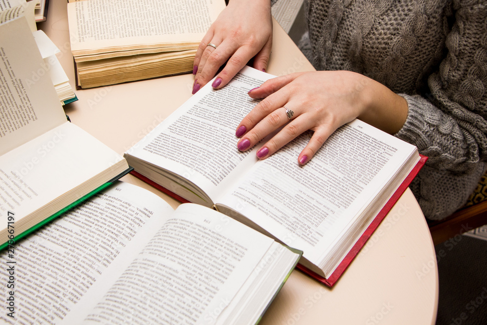 Naklejka premium hand of a woman on old book