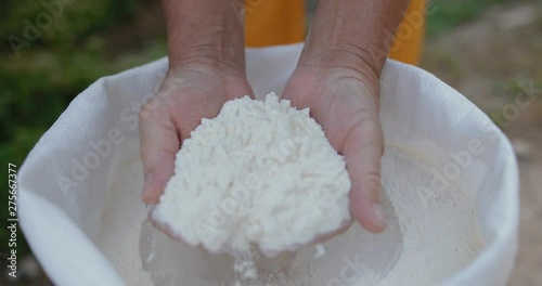 Closeup of the hand of a man taking wheat flour from a bag to hand. in slow motion. Shot on Canon 1DX mark2 4K camera photo