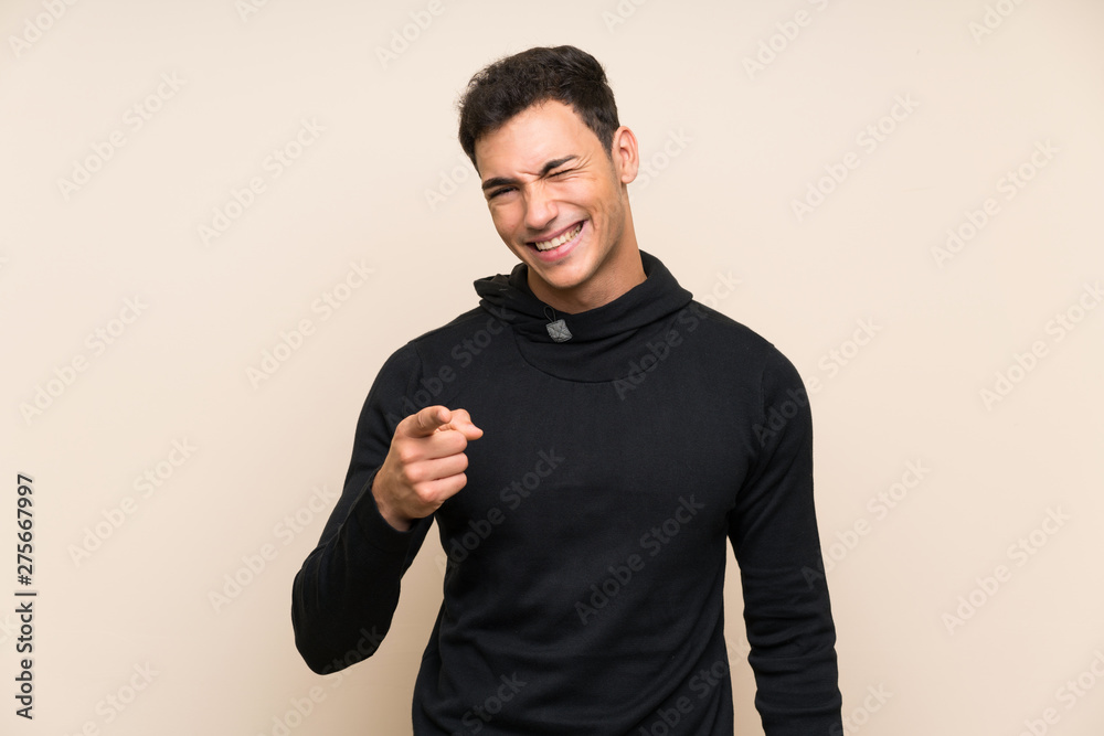 Handsome man over isolated background points finger at you Handsome man over isolated background points finger at you