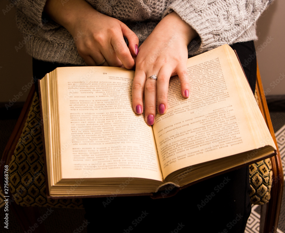 Naklejka premium hand of a woman on old book