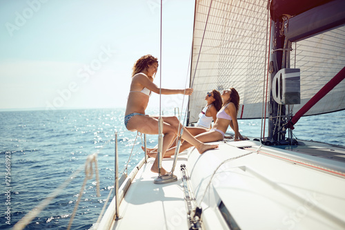 Friends having fun on a boat and enjoying on cruise vacation..