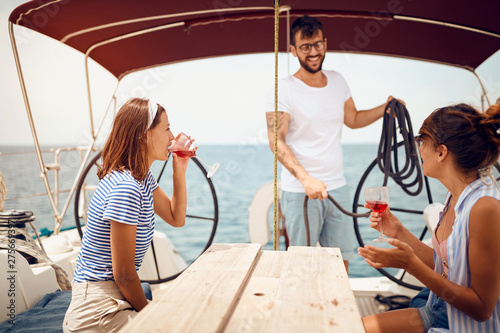 People sitting on sailboat deck and having fun. Vacation, travel, sea, friendship and people concept..