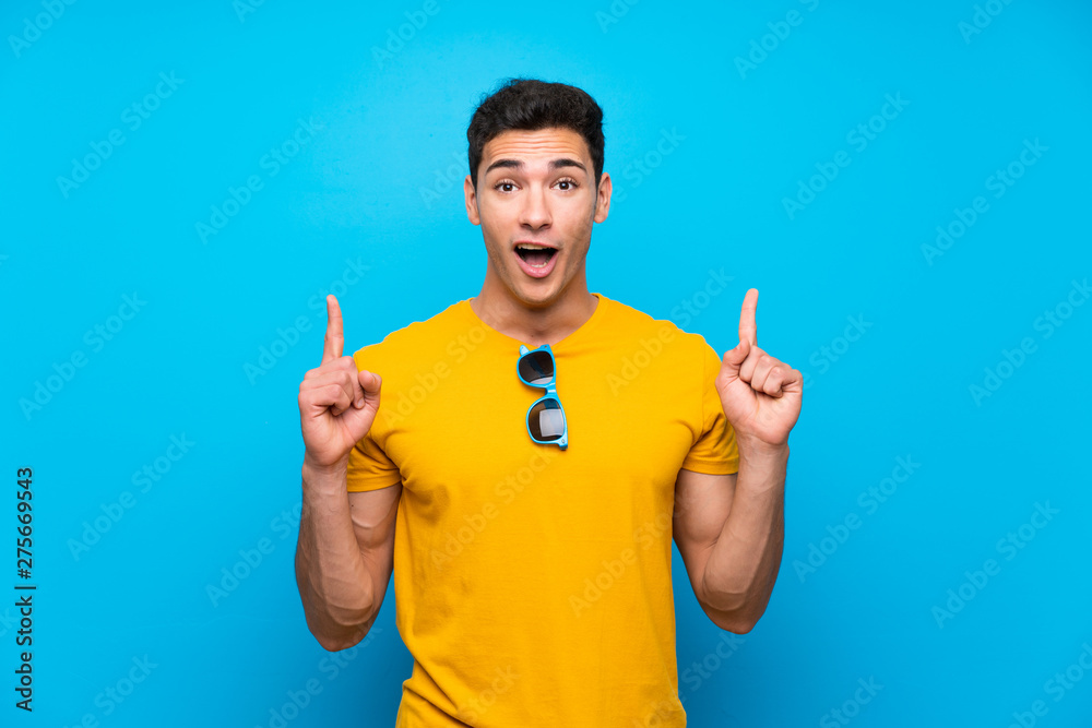 Handsome man over blue background pointing up a great idea Handsome man over blue background pointing up a great idea