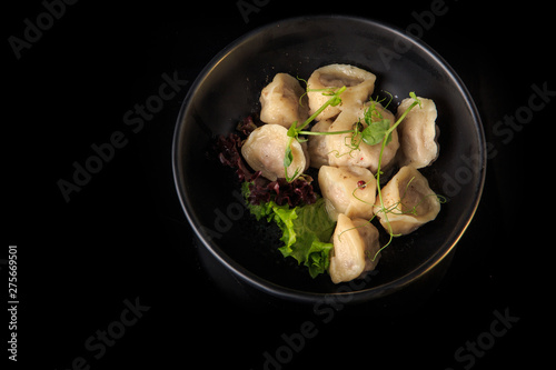 top view of boiled meat dumplings with salad in deep bowl