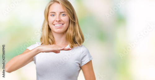 Beautiful young woman wearing casual white t-shirt over isolated background gesturing with hands showing big and large size sign, measure symbol. Smiling looking at the camera. Measuring concept.