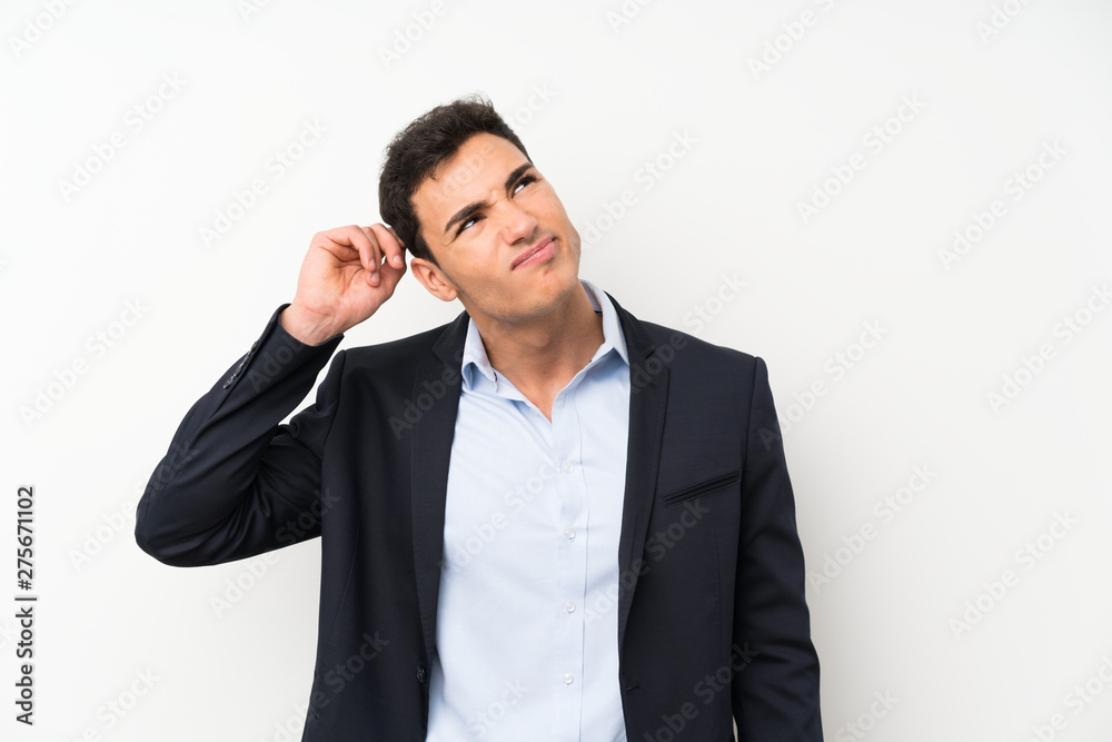 Handsome man over isolated white wall having doubts and with confuse face expression Handsome man over isolated white wall having doubts and with confuse face expression