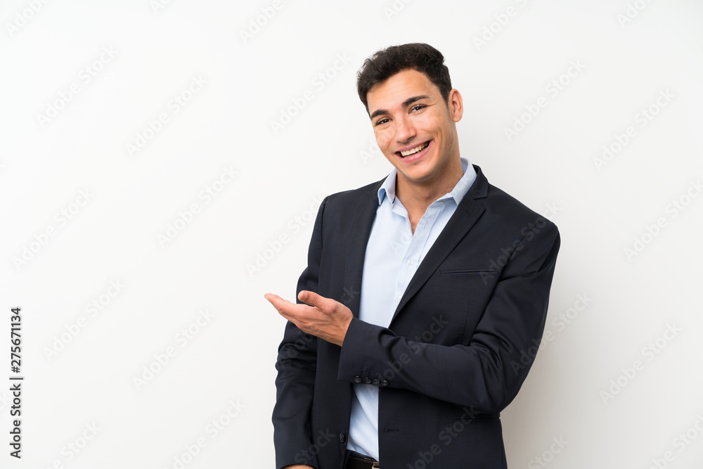 Handsome man over isolated white wall extending hands to the side for inviting to come Handsome man over isolated white wall extending hands to the side for inviting to come