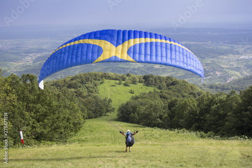 Paraglider taking off from the edge of the mountain photo