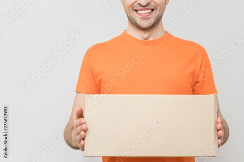 Courier in orange uniform holding the box, white background, close up, background, copy space, advertising, text, slogan
