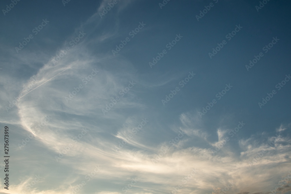 white cirrus cloudy on blue sky in the evening .