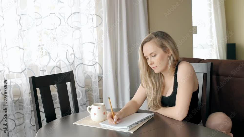 Beautiful lady writing a list for shopping at home and her son standing near. Beautiful lady writing a list for shopping at home and her son standing near.