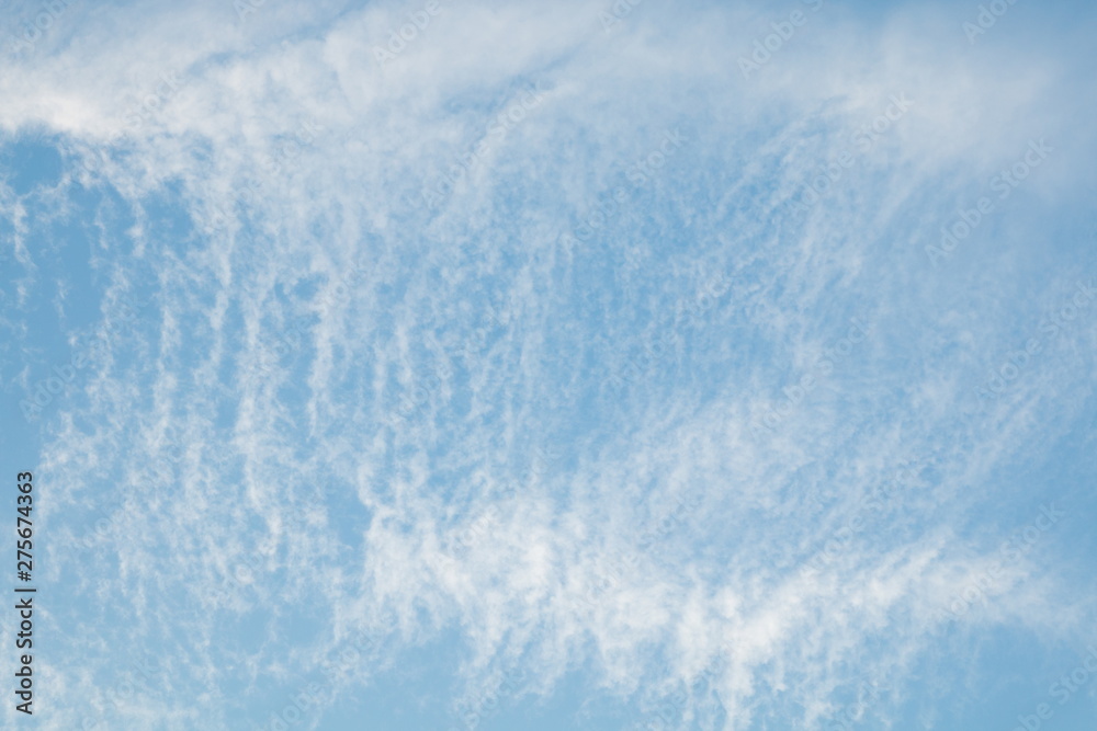 white cirrus clouds in blue sky .