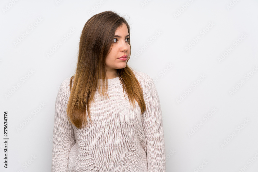 Young girl with white sweater standing and looking side Young girl with white sweater standing and looking side