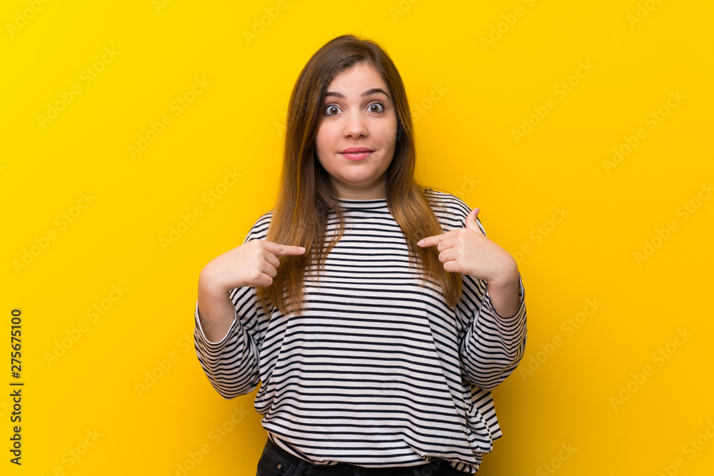 Young girl over yellow wall with surprise facial expression Young girl over yellow wall with surprise facial expression