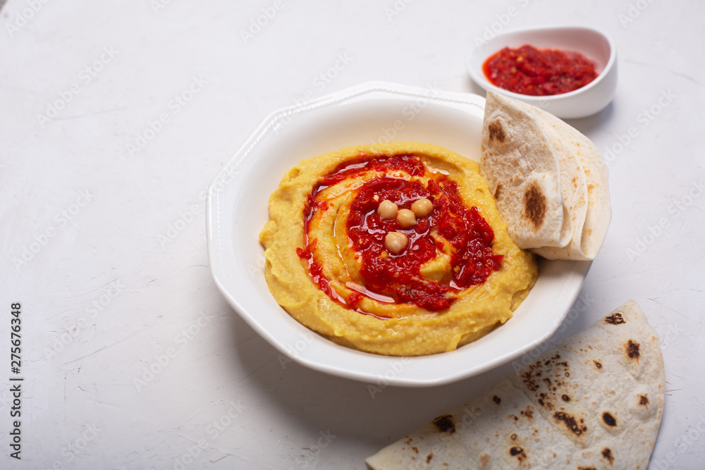 Hummus on a plate. Chickpea dish prepared with harissa sauce Hummus on a plate. Chickpea dish prepared with harissa sauce