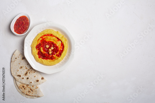 Hummus on a plate. Chickpea dish prepared with harissa sauce