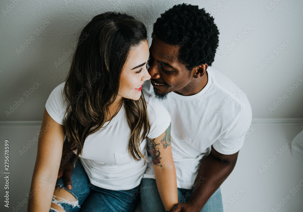 Naklejka premium Happy Biracial Couple in Modern White Room