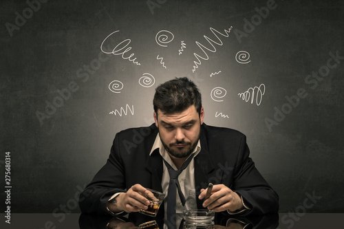 Young drunk man at his office with doodles around 