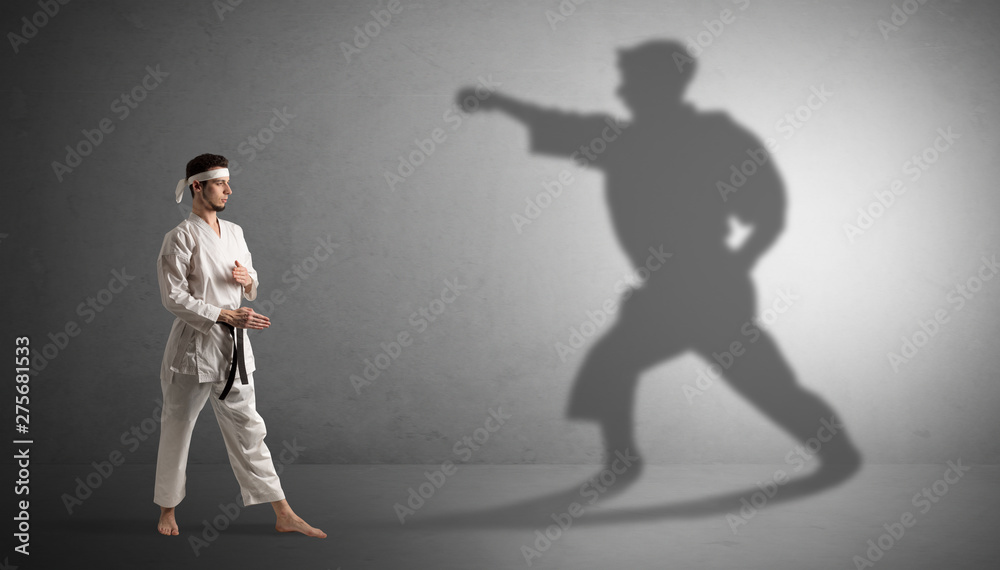 Young karate man confronting with his own shadow
Young karate man confronting with his own shadow