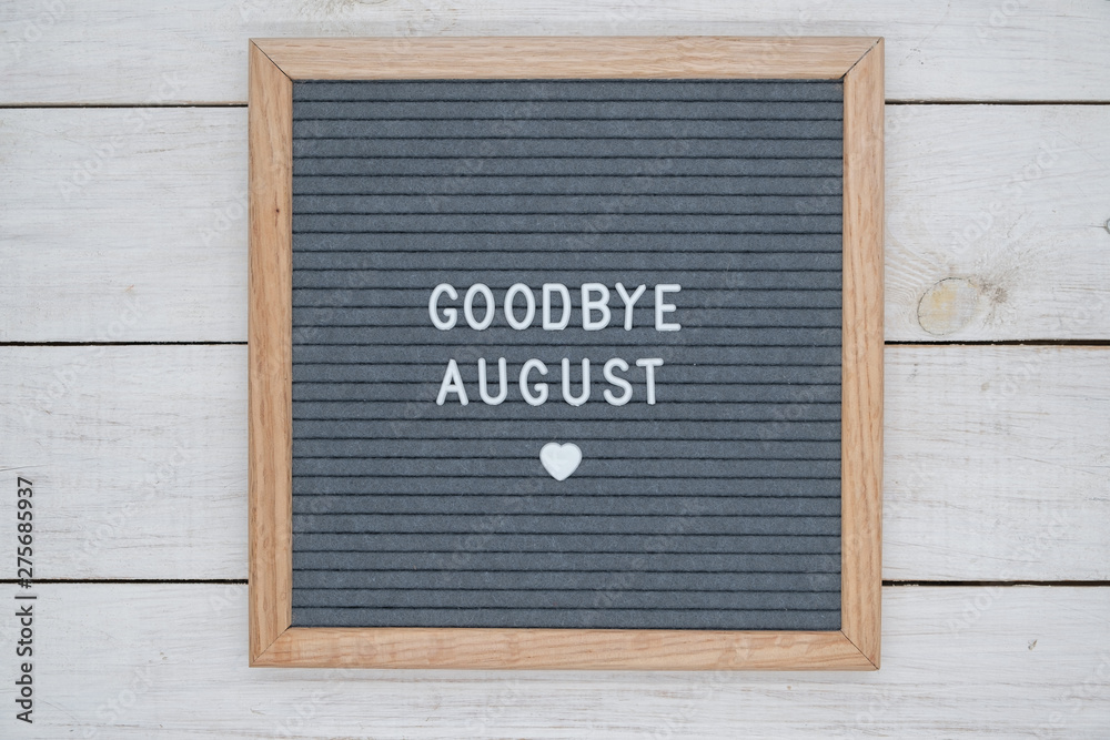 text in English goodbye August and a heart sign on a gray felt Board in a wooden frame