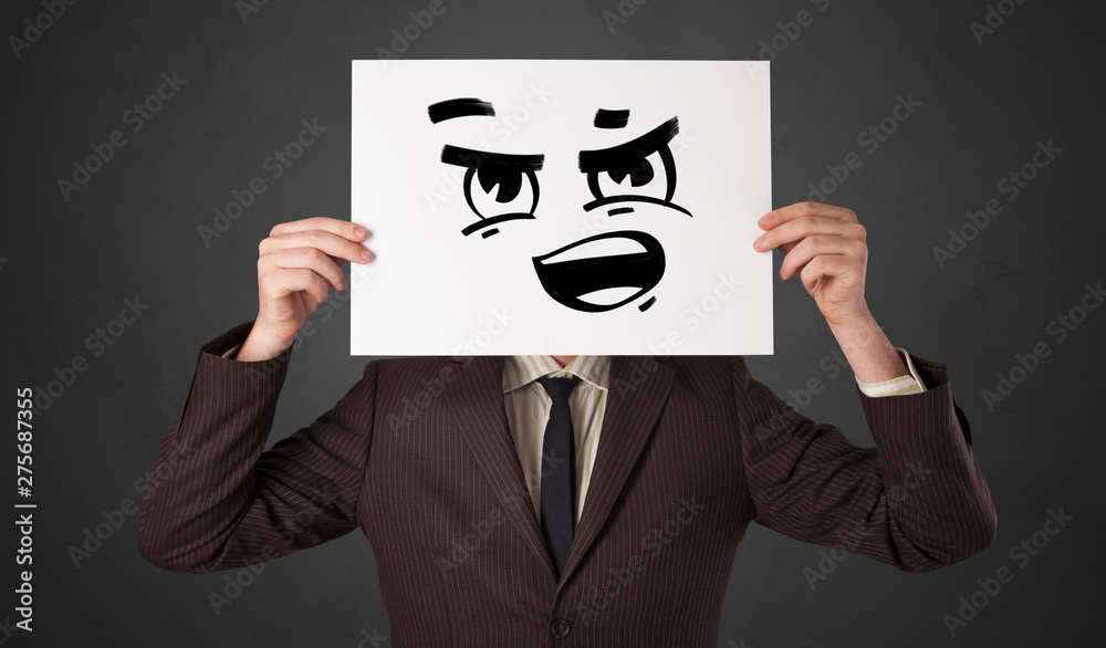 Casual person holding a paper with funny emoticon in front of her face
Casual person holding a paper with funny emoticon in front of her face