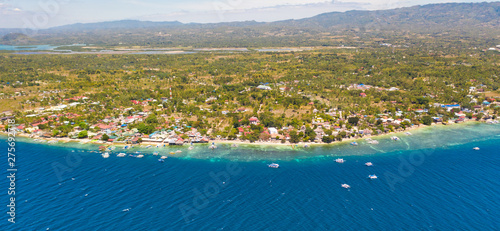 Coast of Cebu island, Moalboal, Philippines, top view. Philippine boats in a blue lagoon over coral reefs. Moalboal is a great place for diving and vacations.