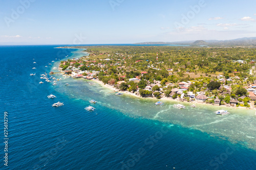 Coast of Cebu island, Moalboal, Philippines, top view. Philippine boats in a blue lagoon over coral reefs. Moalboal is a great place for diving and vacations.
