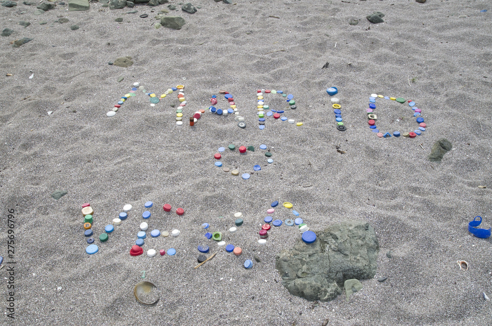 Inscription on the beach of plastic caps Inscription on the beach of plastic caps