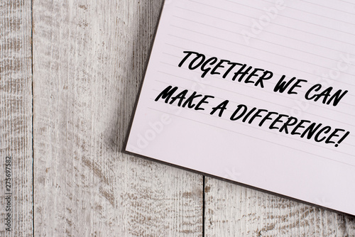 Conceptual hand writing showing Together We Can Make A Difference. Concept meaning be very important some way in like team or group Notebook stationary placed above classic wooden backdrop photo