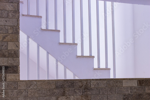 interior design of living studio room with brown brick wall and white stairs background 