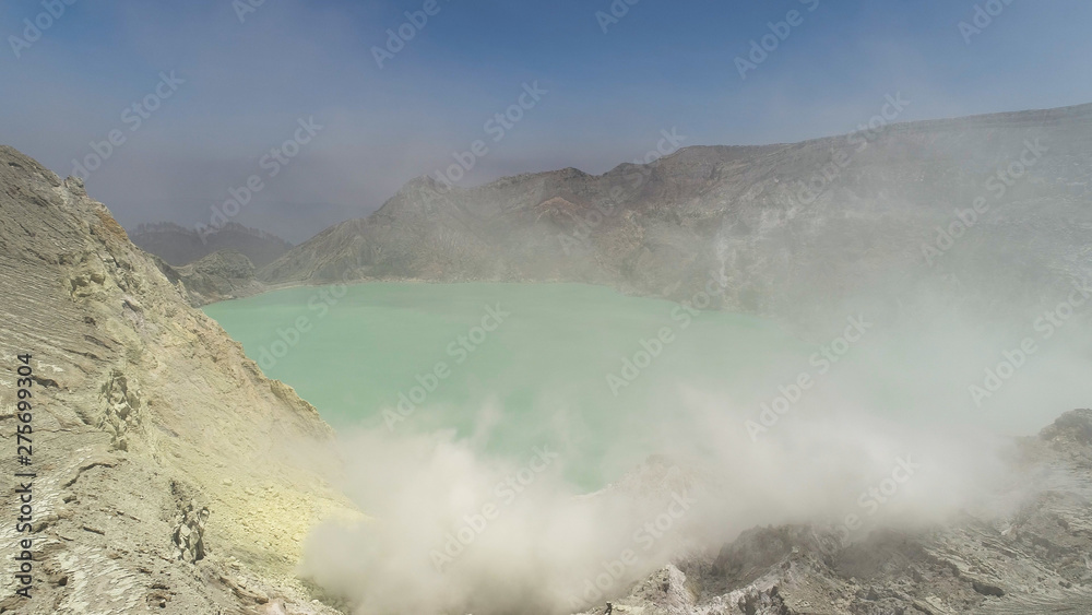 Aerial view mountain landscape with crater acid lake Kawah Ijen where sulfur is mined. Sulfur gas, smoke. Ijen volcano complex group of stratovolcanoes in East Java Indonesia Aerial view mountain landscape with crater acid lake Kawah Ijen where sulfur is mined. Sulfur gas, smoke. Ijen volcano complex group of stratovolcanoes in East Java Indonesia