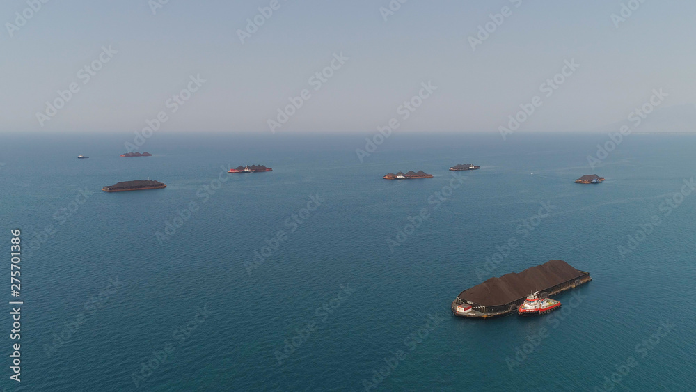 aerial view barges full coal anchored at sea near coal fired power station waiting be transported. coal barges and tugboats java, paiton indonesia