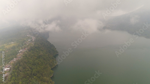 lake Buyan shores covered with tropical vegetation on cloudy day. mountain with slopes covered tropical vegetation. Bali Landscape, lake among mountains, sky, clouds. photo