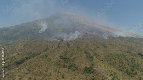 slopes volcano with forest fire, farmland at foot of the volcano Agung. tropical landscape aerial view mountains are covered with forest. Bali, Indonesia.