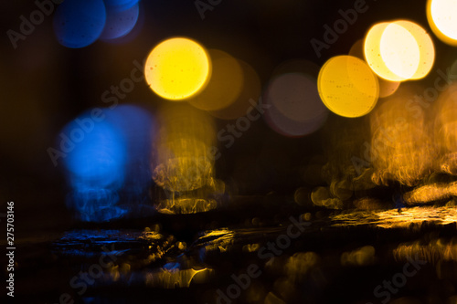 Blurred city lights with rain on the paving stone
