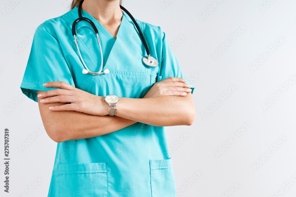 Woman doctor in blue uniform standing with crossed arms, isolated. Woman doctor in blue uniform standing with crossed arms, isolated.