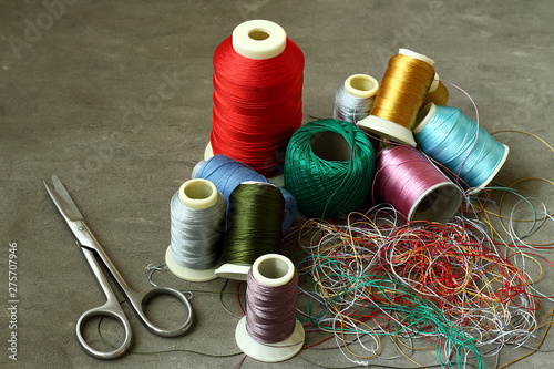 Scissors, tangled colored threads and spools. photo