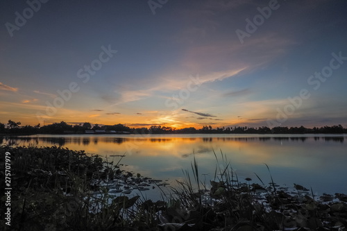 Lake view morning of yellow sun light with cloudy sky, sunrise at Krajub reservoir, Ban Pong District, Ratchaburi, Thailand.