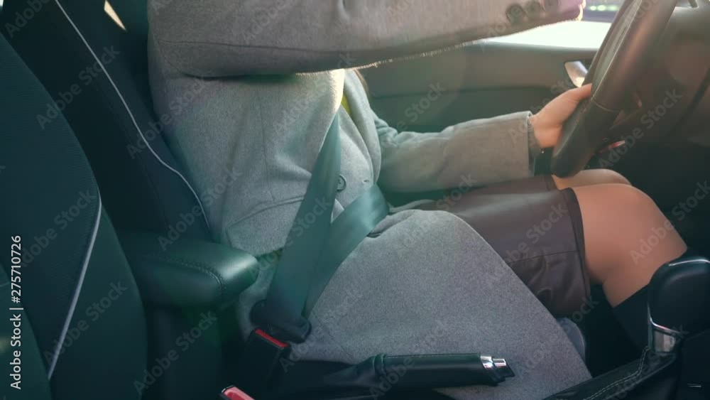 Woman fastening car safety seat belt while sitting inside of vehicle before driving Woman fastening car safety seat belt while sitting inside of vehicle before driving