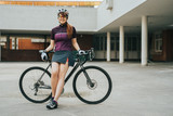 Woman posing next to her bicycle.