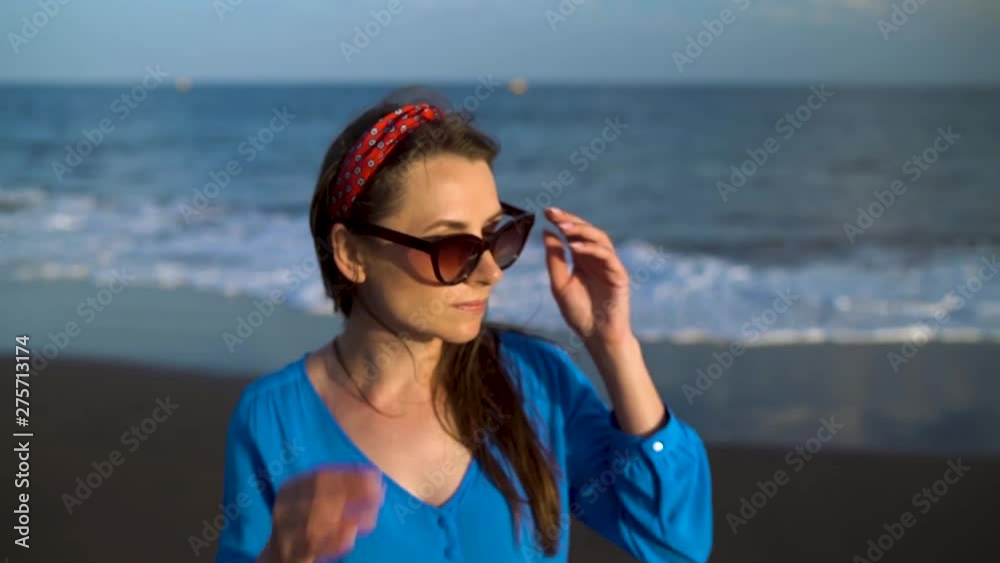 Portrait of a woman in a beautiful blue dress on a black volcanic beach. Slow motion Portrait of a woman in a beautiful blue dress on a black volcanic beach. Slow motion