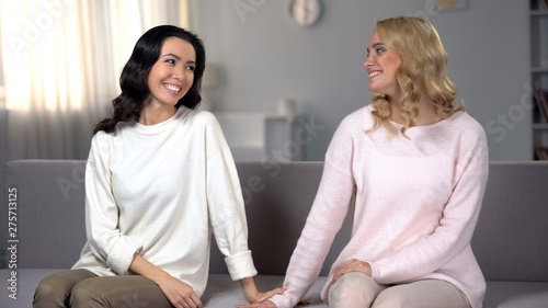 Photos Beautiful female friends holding hands and smiling, reconciling after quarrel