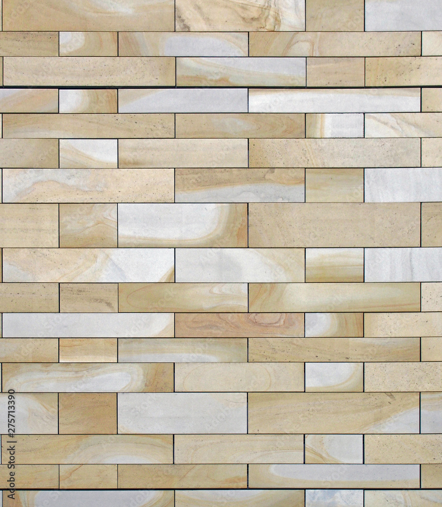full frame image of a wall made of large flat blocks of yellow and grey york stone with a marbled texture full frame image of a wall made of large flat blocks of yellow and grey york stone with a marbled texture