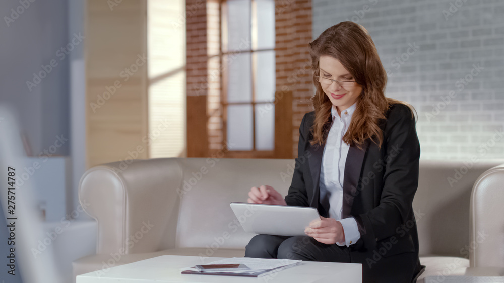 Positive lady using tablet for business or online courses, remote education Positive lady using tablet for business or online courses, remote education