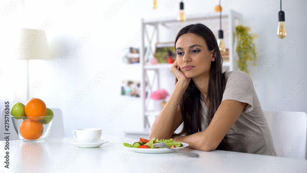 Lady dissatisfied with salad, dreaming about junk food, healthy low-calorie diet
