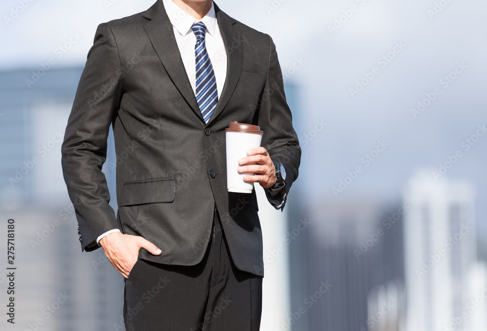 Businessman standing in the city holding cup of coffee. Businessman standing in the city holding cup of coffee.