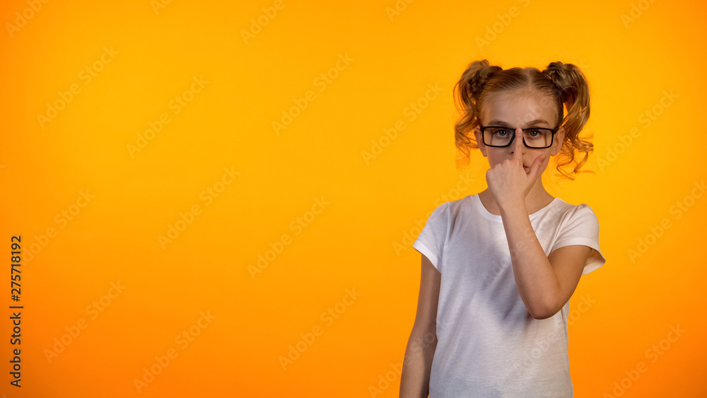 Nice preteen schoolgirl adjusting glasses and looking to camera, ophthalmology Nice preteen schoolgirl adjusting glasses and looking to camera, ophthalmology