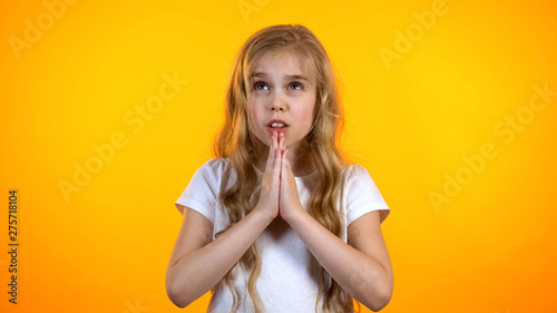 Fotografija Little girl praying for dearest wish come true anxious before exam advertisement